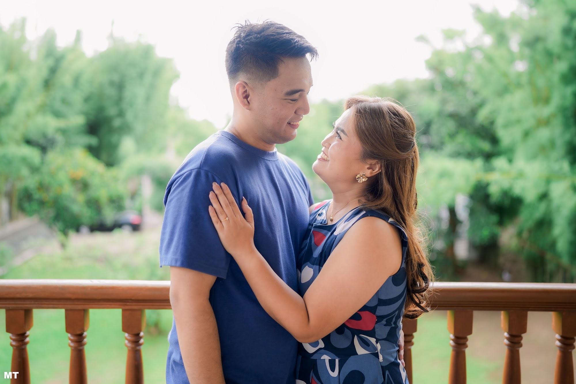 Paulo and Laddie embracing on a wooden balcony